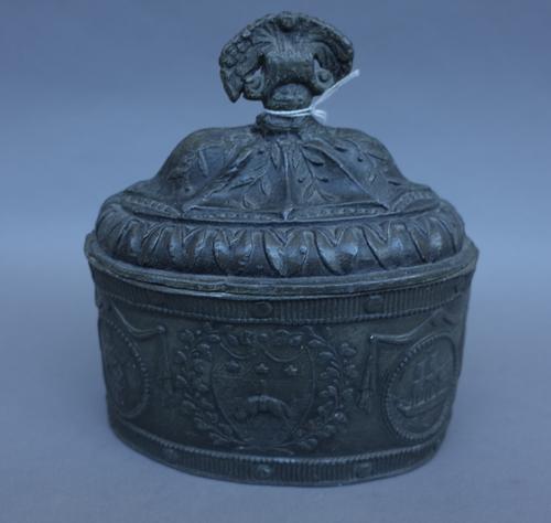 An 18th century pewter tobacco box and cover, possibly Leeds, embossed decoration of hanging sheep against an oval body (16cm wide), an 18th century b