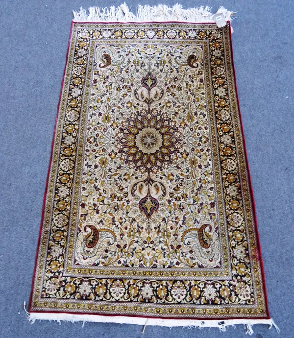 A silk rug, sun bleached gold white main field with lobed circular medallion, boteh spandrels, 165cm x 106cm.