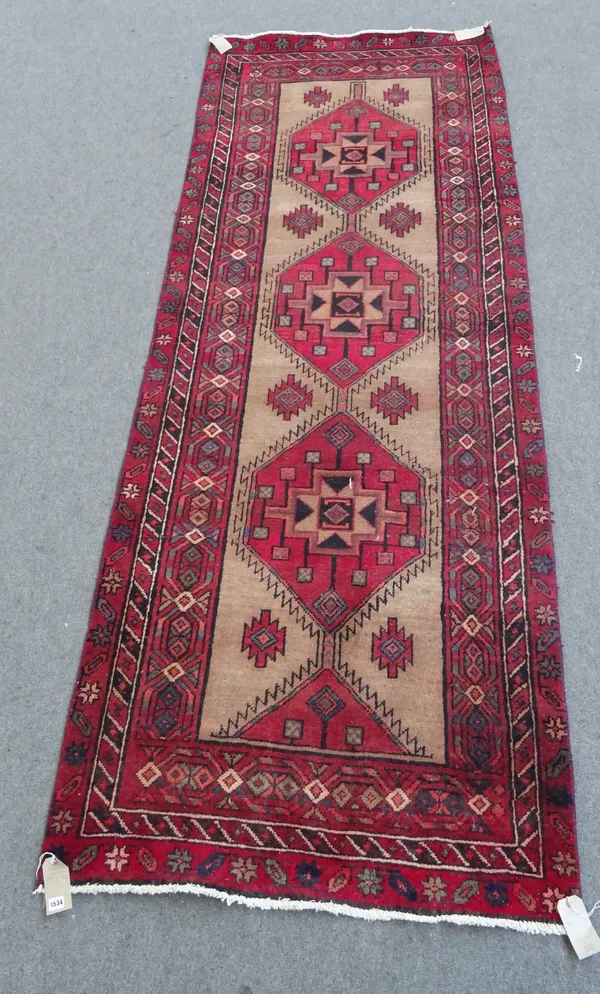 A North West Persian runner, the natural field with three large madder diamonds, a lozenge border, 317cm x 116cm.