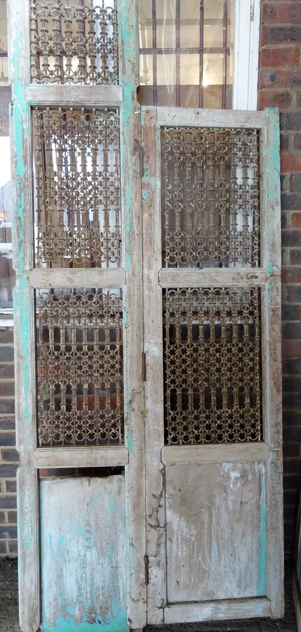 Four sections of 19th century Indian room divider/ Jali screens, the hardwood frame with traces of original green paint, inset with wrought iron trell