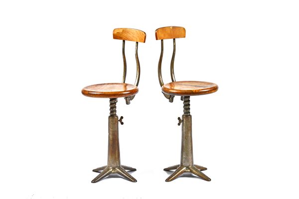 SINGER; a pair of 20th century beech and cast iron height adjustable stools on four point base, the seat, 36cm wide. Illustrated