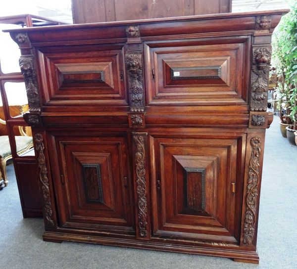 A 17th century and later Indo-Dutch rosewood side cabinet with two pairs of raised panelled doors divided by cushion drawers and lion mask mounts, 171