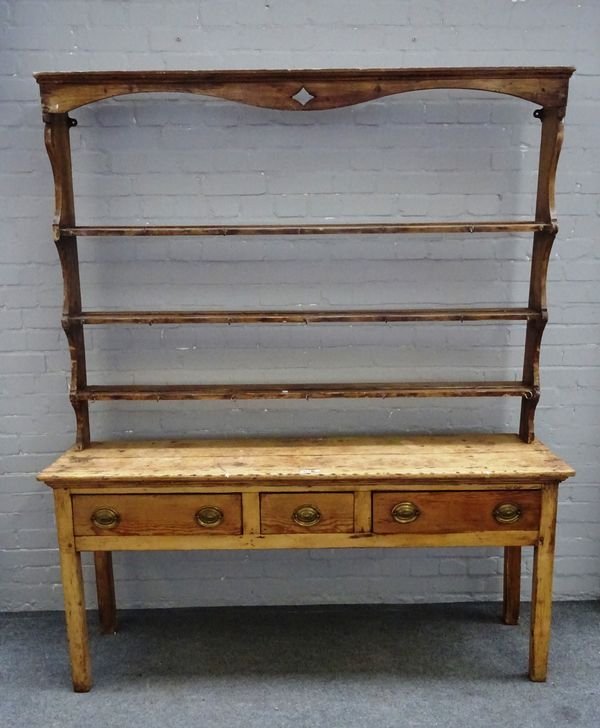 An early 19th century pine dresser, the open three tier plate rack over three frieze drawers, on block supports, 157cm wide x 198cm high x 45cm deep.