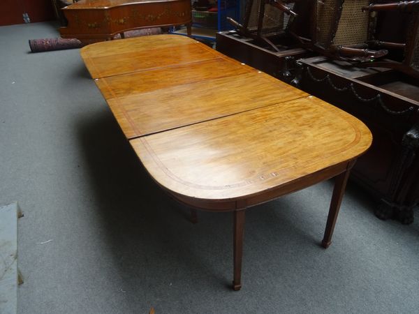 A George III satinwood inlaid mahogany triple section extending dining table, with centre drop flap and pair of 'D' shaped end sections, on tapering s