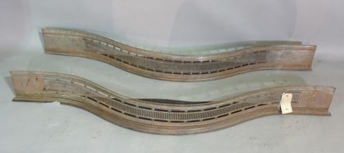 A near pair of early 20th century serpentine steel fire fenders, 122cm long, (2).   H8