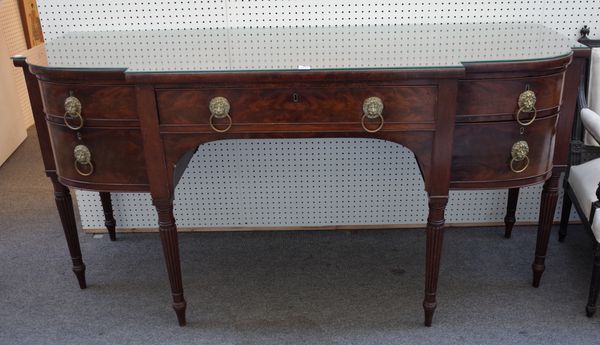 A George IV bowfront mahogany sideboard with five frieze drawers on tapering reeded supports, 183cm wide x 92cm high x 68cm deep.