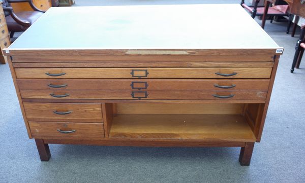 A mid-20th century oak architect's table, the sliding angle top over an arrangement of three long and two short drawers with opposing bookshelf, 148cm