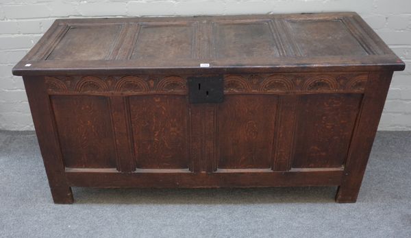 A 17th century oak coffer with four panel lid and front and double panel sides on stile feet, 143cm wide x 69cm high x 59cm deep.