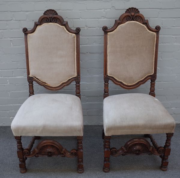 A pair of late 19th century carved oak side chairs of 17th century Flemish design with pierced stretcher on block and turned supports, 53cm wide x 125