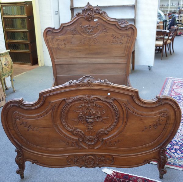 A pair of French Louis XV style beds, each with shaped and carved head and foot board, 150cm wide x 155cm high x 200cm long.