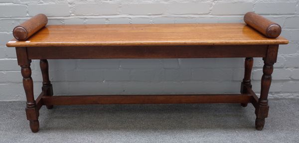 A Victorian style oak window seat with turned end stops and supports, united by stretcher, 122cm wide x 55cm high x 37cm deep.