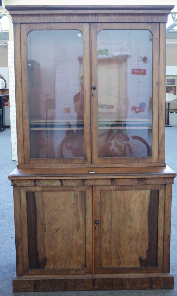 A Victorian figured walnut display cabinet cupboard, the pair of glazed doors over lower panel cupboard on plinth base, 124cm wide x 211cm high x 44cm