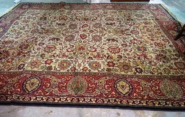 A machine made carpet, fawn field decorated in a variant of a Tabriz animal pattern,  374cm x 271cms.  H4