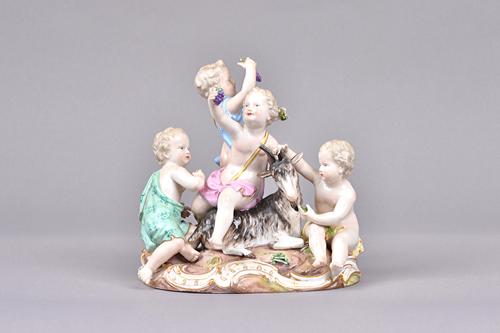 A Meissen porcelain allegorical figure group, late 19th century, emblematic of Autumn, depicting four putto around a goat, holding grapes and vegetabl