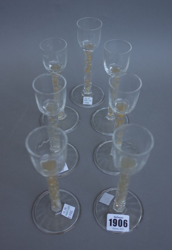 Seven 18th century style wine glasses, each with facet cut stem, gilt inclusions and wide foot, 16.5cm high.