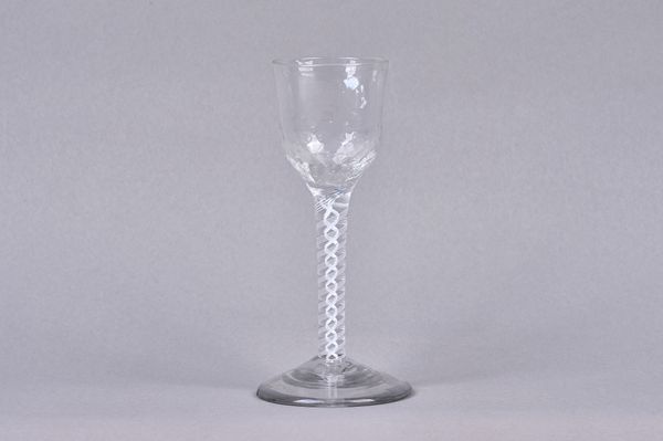 An opaque twist wine glass, circa 1765, the moulded ogee bowl raised on a double-series opaque twist stem and plain foot, 15cm. high. Illustrated