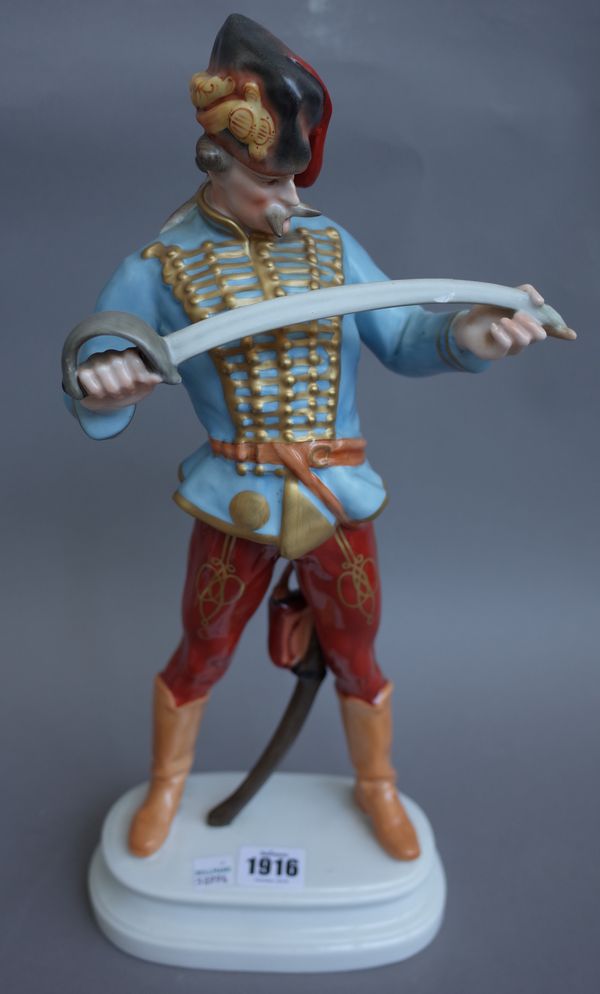 A Herend porcelain 'Hadik Hussar', modelled inspecting his sword, blue printed mark, incised 5055, (a.f), 40cm high.