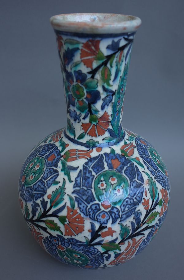 An Iznik style pottery vase, early 20th century, polychrome foliate decoration against a globular body. (a.f.) 31cm high.