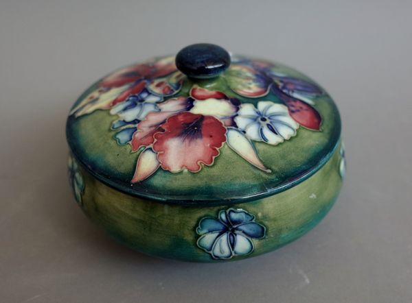 A Moorcroft green-ground circular powder bowl and cover, circa 1935-40, decorated with the `Orchid' pattern, impressed facsimile signature, paper labe