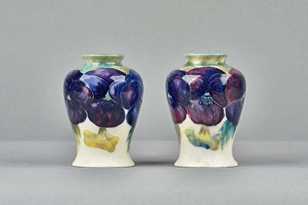 A pair of Moorcroft miniature baluster vases, circa 1916, painted with the `Pansy' pattern, impressed mark, green painted initials, (one a.f), 9.5cm.