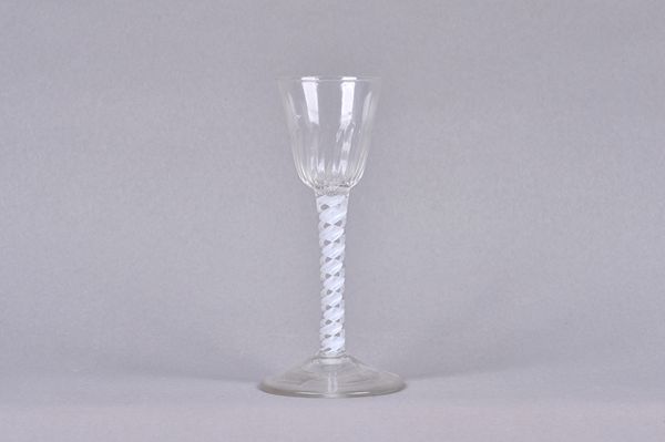 An opaque twist wine glass, circa 1765, the moulded rounded funnel bowl raised on a double-series opaque twist stem and plain foot, 15cm.high. Illustr