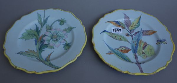 A pair of Porquier-Beau Quimper faience plates, late 19th century, each painted with naturalistic flower studies inside yellow line borders, blue pain