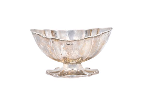 A silver sugar bowl, of panelled shaped oval form, raised on a shaped oval foot, Sheffield 1908, weight 164 gms. Illustrated