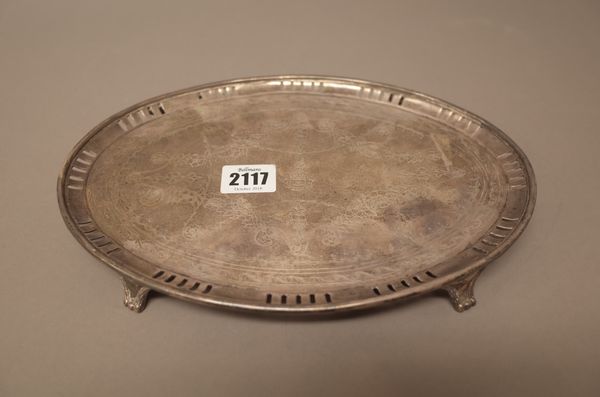 A silver oval small salver, the centre later engraved with floral swags within a later pieced border, the centre crest engraved and raised on three fe