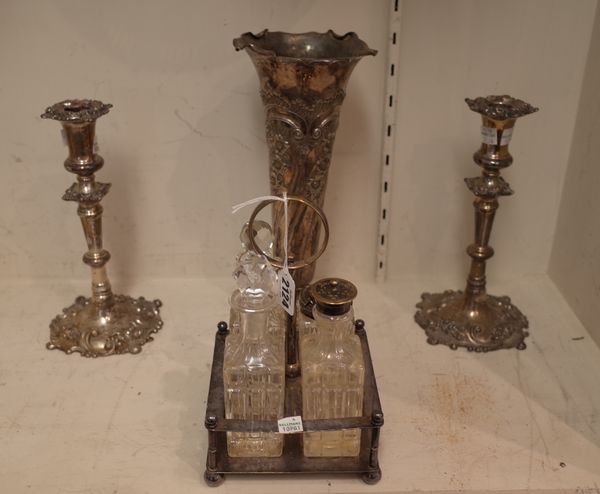 Plated wares, comprising; a four bottle cruet, with a square stand, having a loop shaped handle, a pair of Victorian table candlesticks, having foliat