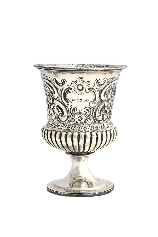 A George IV silver vase, of campana shaped form, with floral, foliate and scroll embossed decoration above a fluted band, raised on a circular foot, h