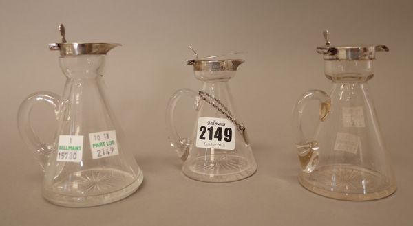 Three silver mounted glass whiskey noggins, having star cut decoration to the bases, various dates and a silver noggin label detailed 'Brandy', London