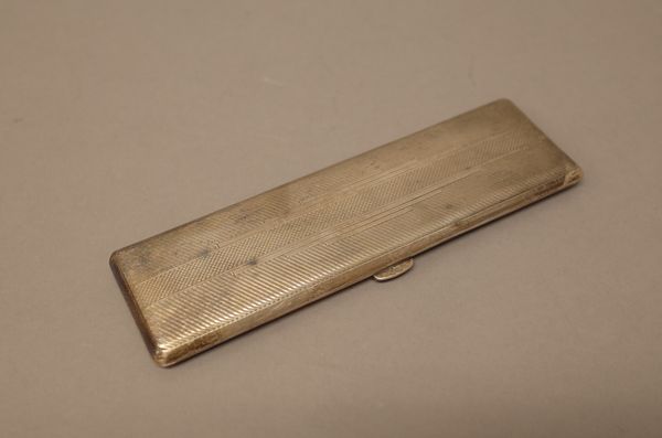 A silver rectangular cigar case, to hold slim cigars, gilt within, the exterior engine turned in the Art Deco taste, size 16.5cm x 5.0cm, Birmingham 1