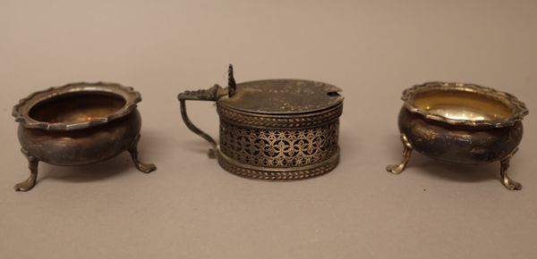 Silver, comprising; a Victorian oval hinge lidded mustard pot, with pierced decoration, London 1880, with a blue glass liner and two similar salts, ea