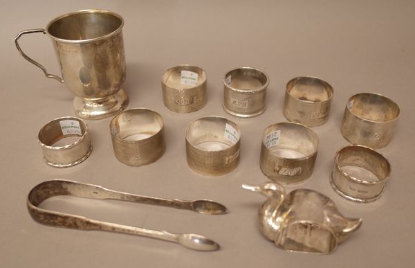 Silver, comprising; a novelty napkin ring, designed as a duck, Birmingham, probably 1913, nine further napkin rings, a pair of fiddle pattern sugar to