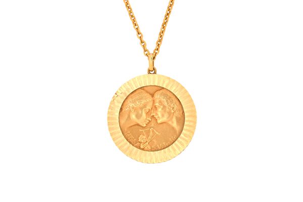 A gold circular pendant, representing St Valentine's Day, the front with two portraits and a cherub, with a gold oval link neckchain, on a boltring cl