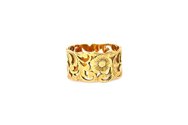 A gold wide band ring, with floral and scrolled foliate pierced and engraved decoration, detailed 750, ring size L, weight 6.2 gms. Illustrated.