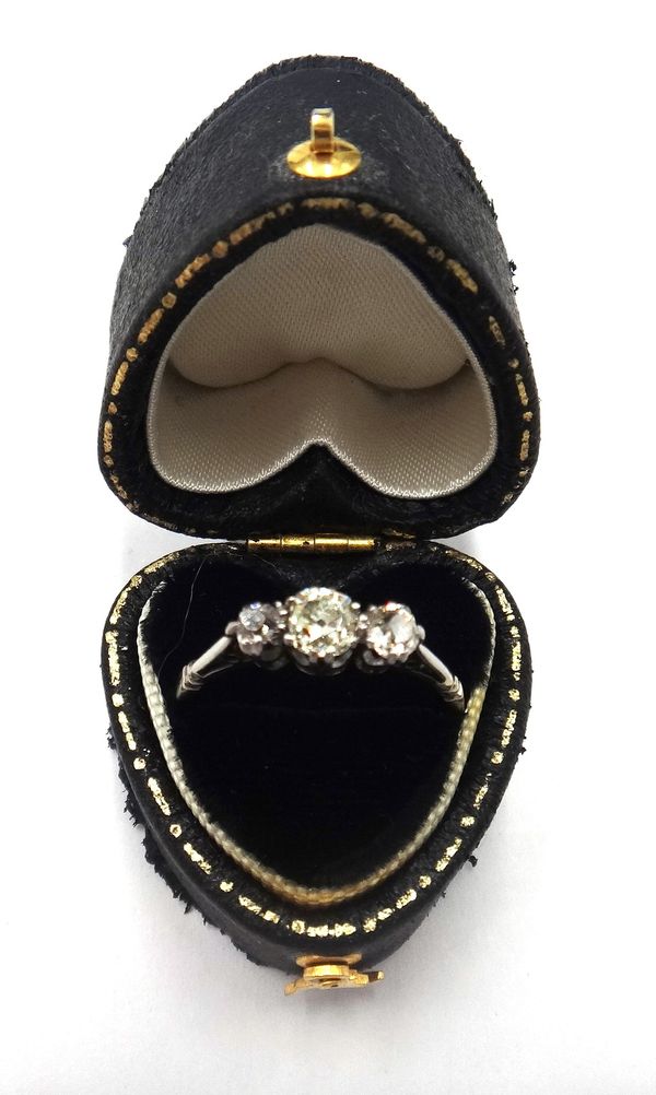 A diamond set three stone ring, claw set with cushion shaped diamonds and with the principal diamond mounted at the centre, ring size O and a half, wi