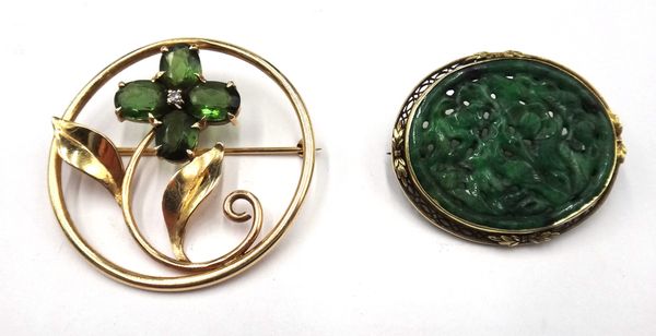 A gold, green tourmaline and diamond set brooch, in a circular openwork design as a floral spray, claw set with four oval cut green tourmalines and wi