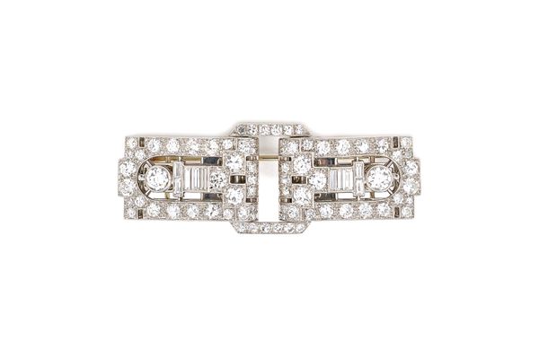 A diamond set Art Deco double clip brooch, in a pierced openwork geometric design, mounted with circular cut and baguette diamonds and with a principa