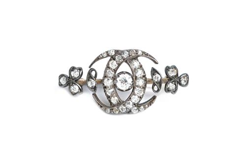 A late Victorian diamond brooch, in a twin crescent and trefoil design, mounted with the principal cushion shaped diamond at the centre and otherwise