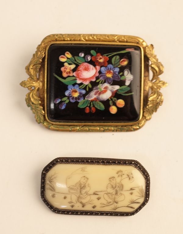 A Victorian gilt metal mounted rectangular opaque black glass brooch, decorated with a floral spray, the mount with foliate motifs to the sides and a