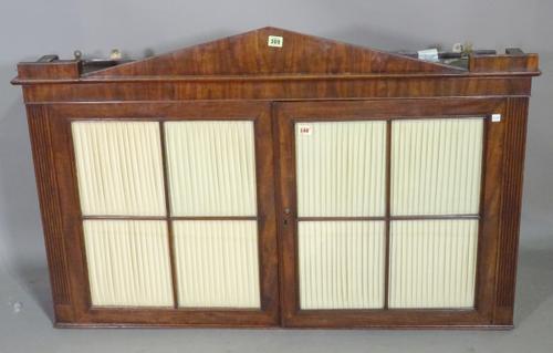 An early 19th century continental mahogany hanging two door cabinet, with architectural cornice, 122cm wide x 80cm high x 25cm deep.  K9