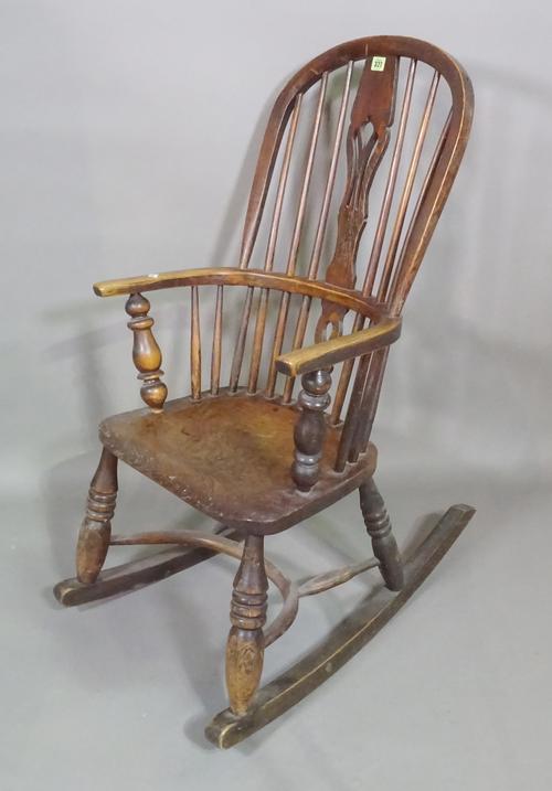 A 19th century ash and elm stick back rocking open armchair on ring turned tapering supports.   D8