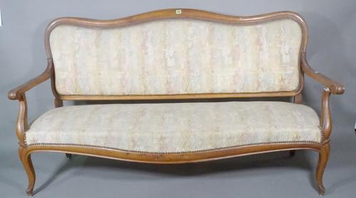 A 19th century French walnut hump back sofa with open arms on cabriole supports, 171cm wide.   C7
