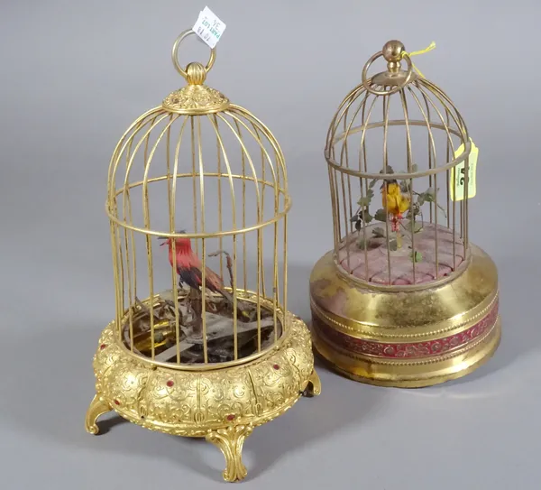 A brass cased musical bird cage and another. The larger 30cm tall.  CAB
