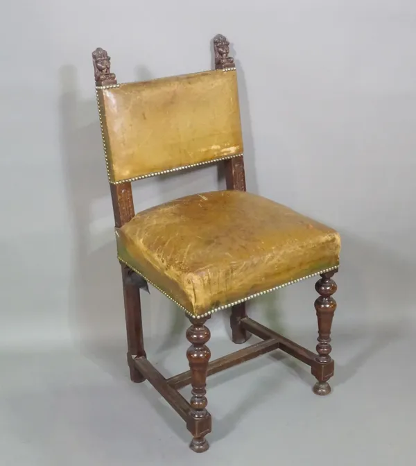 A 17th century style oak square back dining chair with carved lion finials, on ring turned supports.  C7