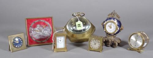 A square and red enamel strut timepiece, an octagonal shaped brass world time desk clock with glass spheres, a miniature brass carriage timepiece, a d