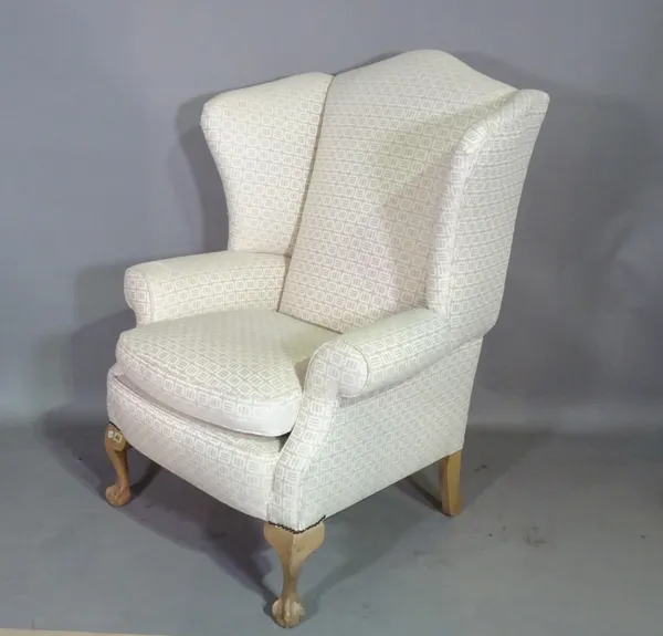 A 20th century wingback armchair on ball and claw feet.   F7