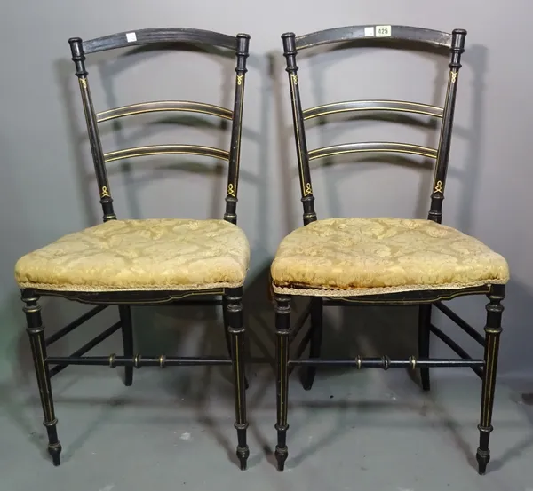 A pair of Edwardian ebonised bar back dining chairs on tapering supports.   BAY 3