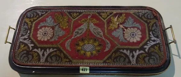 An Edwardian ebonised and ormolu banded two handled tray with inset beadwork panel of flowers on bun feet, 59cm wide.   S4T
